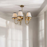 Elegant brass chandelier with fabric lampshades adding soft warm glow in a modern living room interior