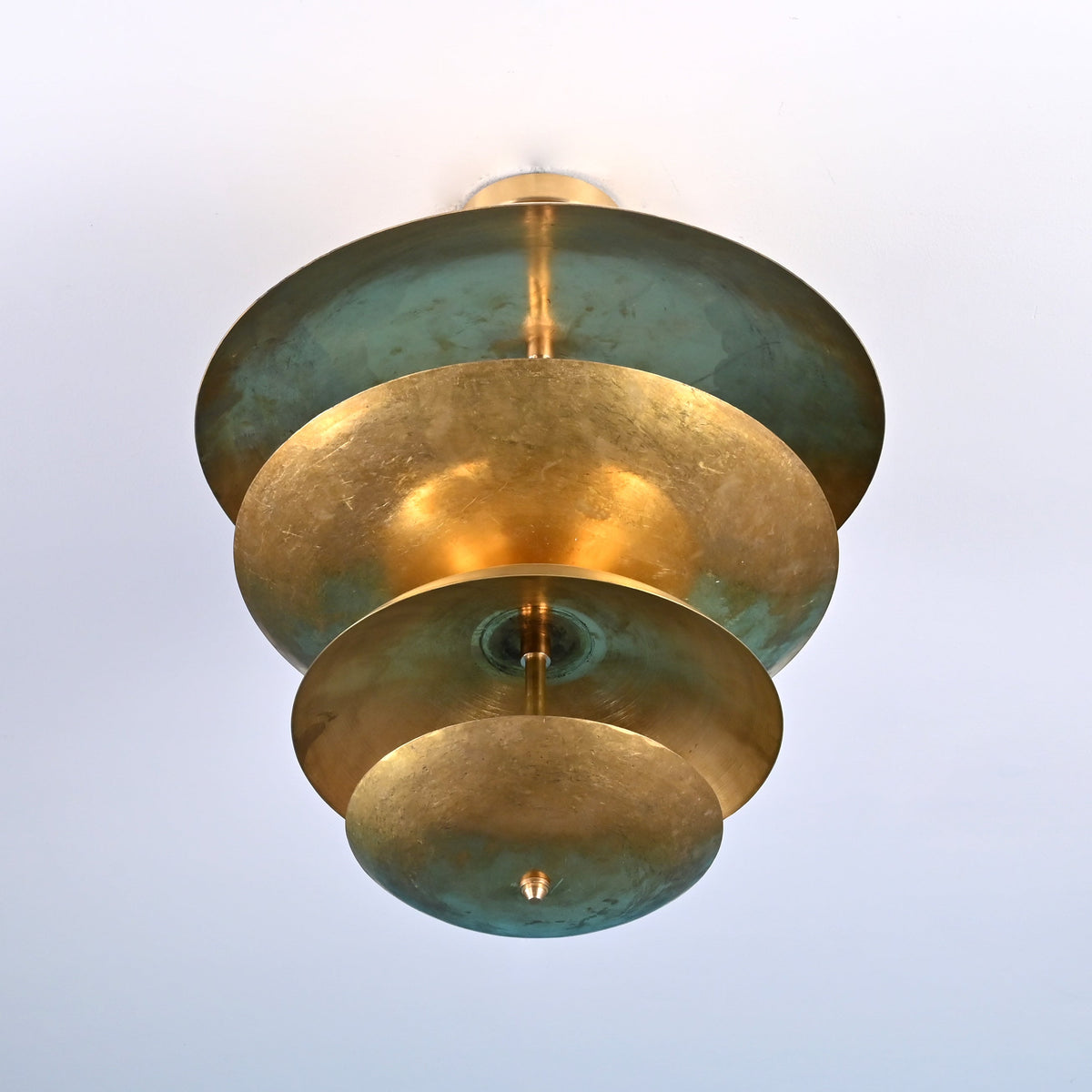 Bottom view of layered brass flush mount ceiling light showing concentric disc design and solid brass construction.