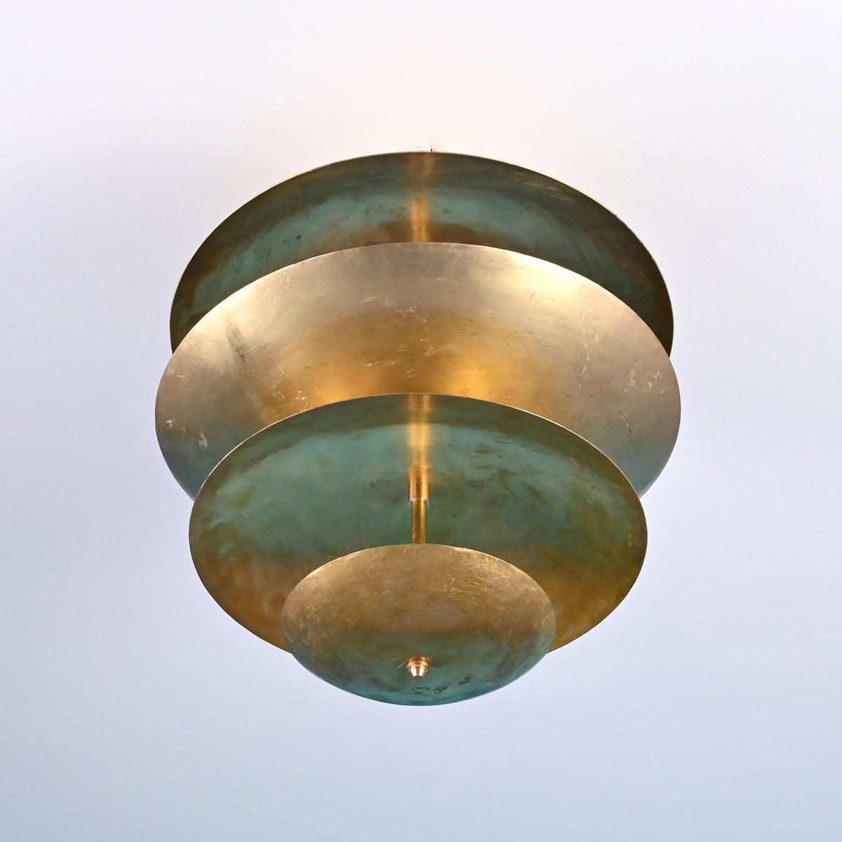 Bottom view of layered brass flush mount ceiling light showing concentric disc design and solid brass construction.