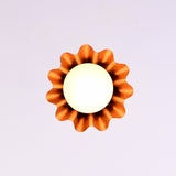Bottom view of modern brass fluted disc pendant light with glowing glass globe and warm ambient illumination.