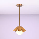 Minimalist brass fluted pendant light hanging straight with sculpted shade and glowing globe.