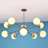 Symmetrical modern brass chandelier with opal globe shades arranged in a sculptural radial pattern.