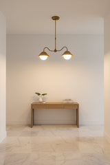 Modern brass globe pendant lamp with two G9 lights and sculptural curved frame for warm ceiling illumination