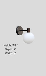 Brass wall sconce with globe shade showing dimensions 7.5 inch height, 7 inch depth, 5 inch width