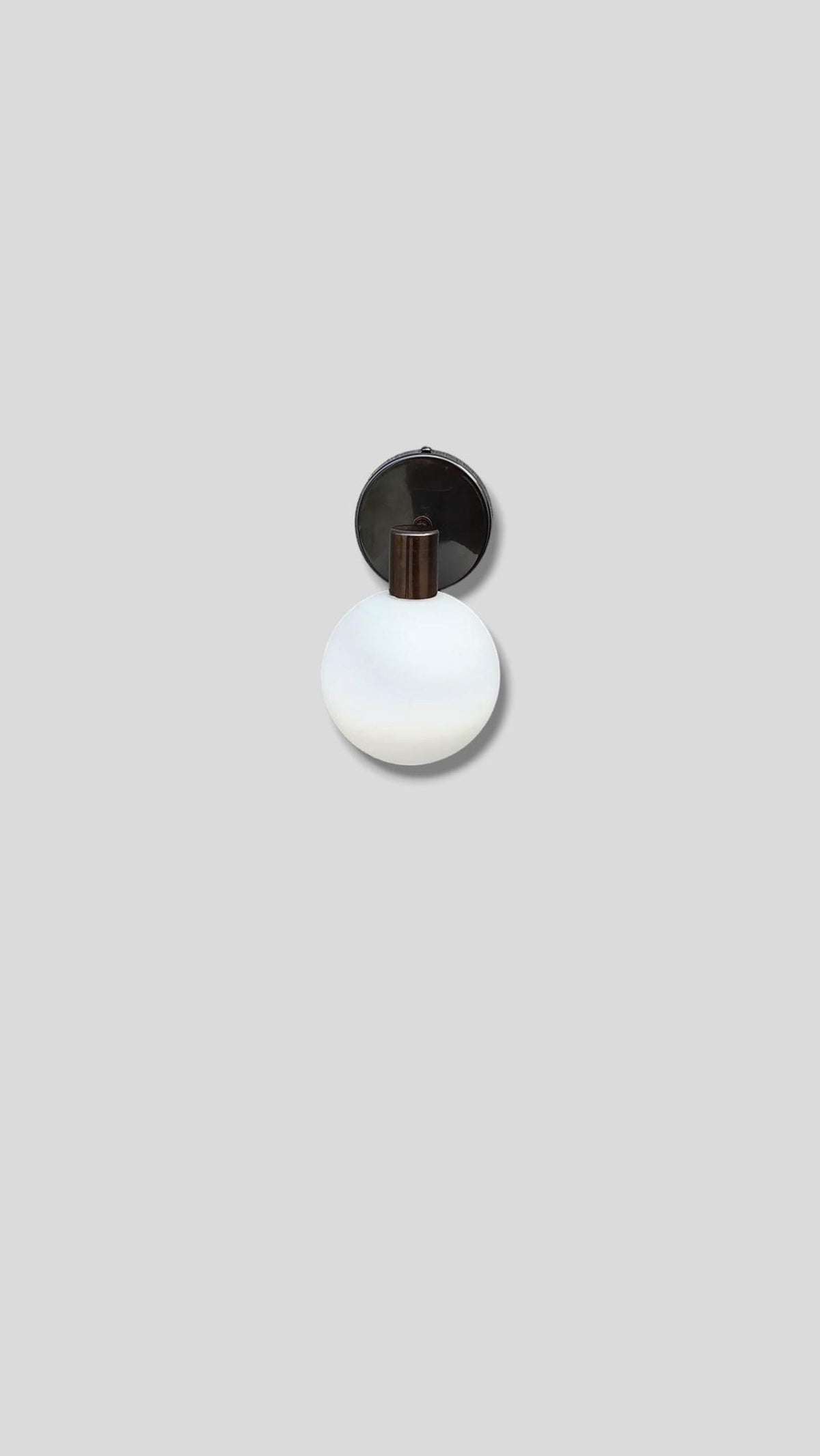 Top view of handcrafted brass wall light with frosted glass globe