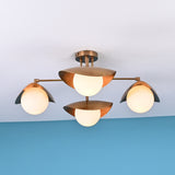 Front view of 4 light brass flush mount ceiling fixture with opal globe shades and sculpted bowl design