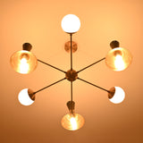 Bottom view of a 9-light brass chandelier featuring illuminated cone shades and opal globes arranged in a radial layout.