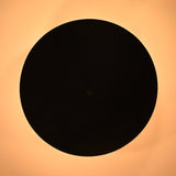 Bottom view of a matte black bowl ceiling light casting a circular warm halo of light on the ceiling.
