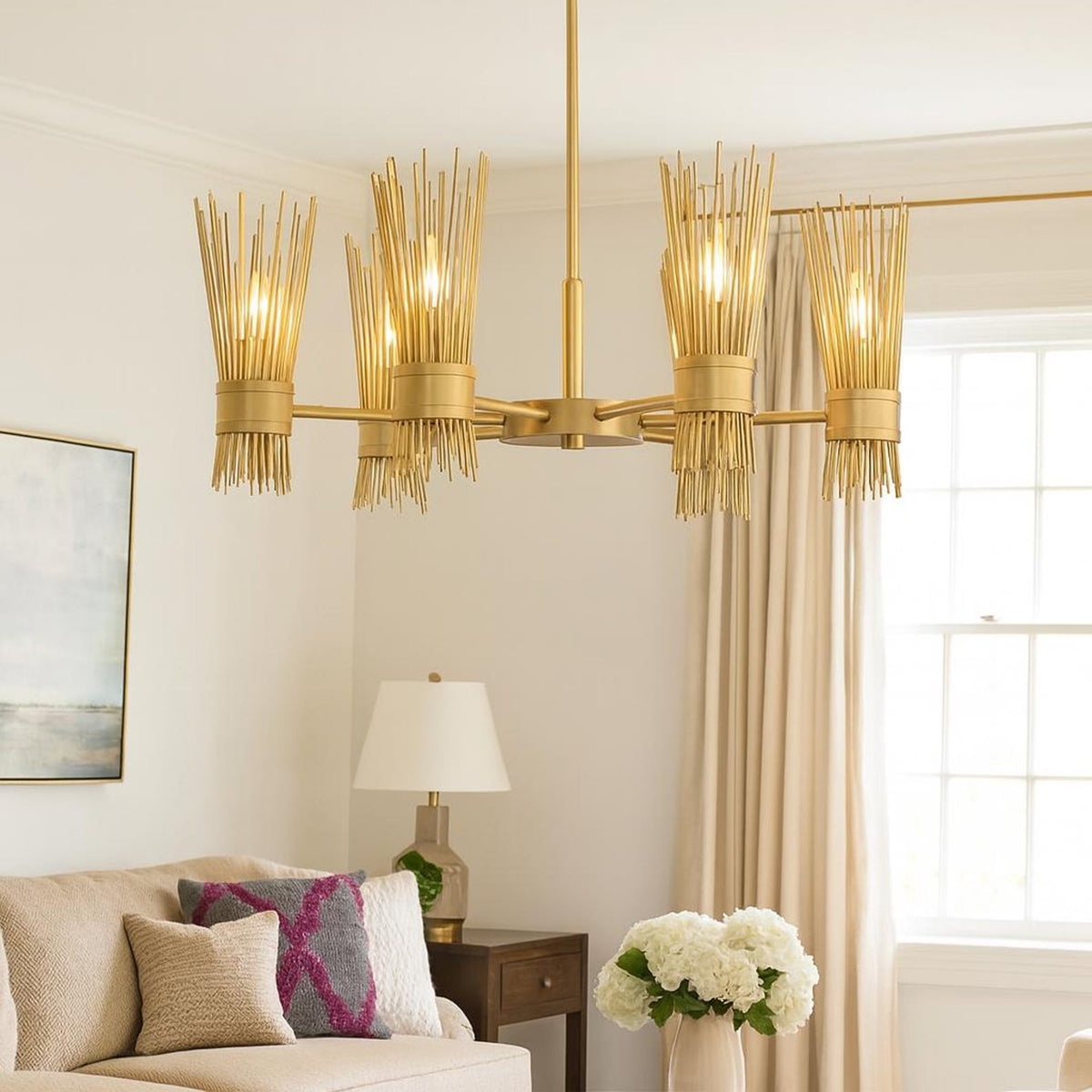 Handcrafted brass reed chandelier with six lights illuminating a modern living room, featuring brushed brass finish and soft indirect glow.