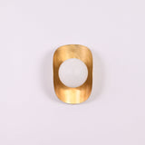 Brass Leaf Studio crescent wall light with opal globe and warm decorative wall illumination