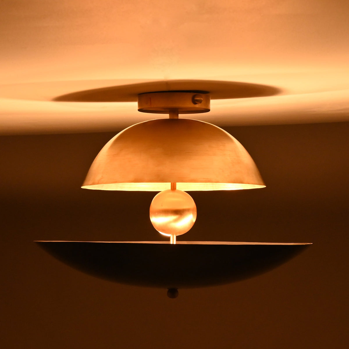 Night view of a dome and bowl chandelier showing warm ambient illumination and dramatic upward and downward glow patterns.