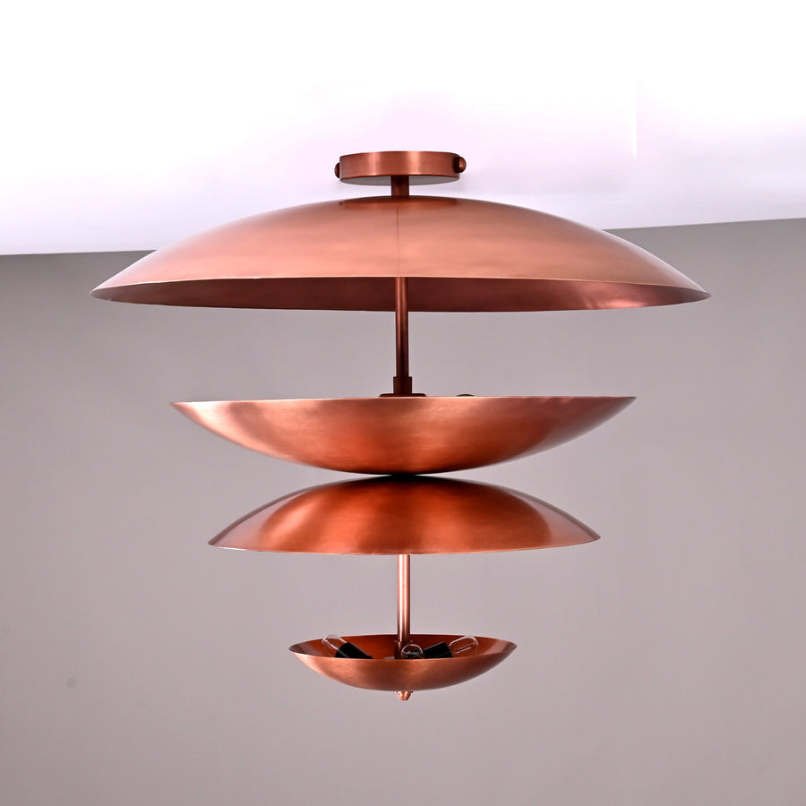 Front view of a 24x21 inch handmade multi-tier brass flushmount chandelier featuring sculpted bowl-shaped shades in a copper finish by Brass Leaf Studio.