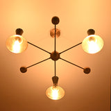 Night-view of a mid-century modern brass chandelier with cone shades emitting soft ambient lighting.