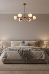 Brass Leaf Studio Monaco chandelier featuring six white glass globes and industrial grade brass construction