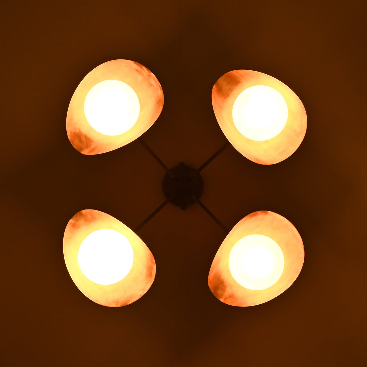 Night bottom view of opal globe brass ceiling light casting soft indirect lighting