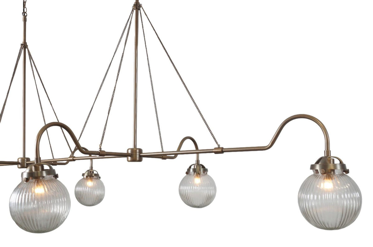 Close-up of ribbed glass globes and brass frame detailing – handcrafted linear chandelier by Brass Leaf Studio
