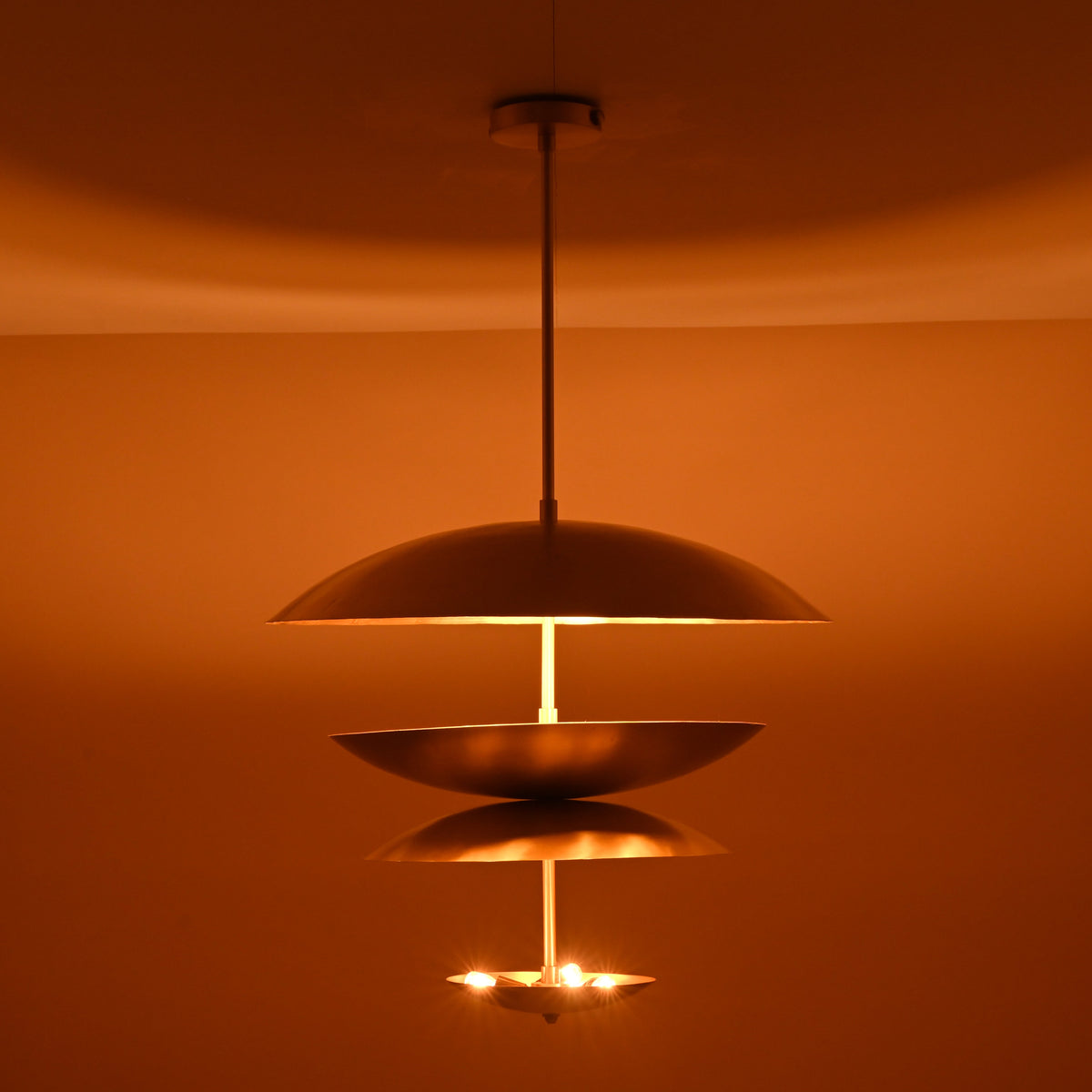 Warm ambient glow from triple bowl brass chandelier with brushed finish, handcrafted by Brass Leaf Studio