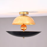 Two-tone dome and bowl flushmount chandelier featuring brushed brass and matte black shades with a sculptural brass sphere centerpiece.