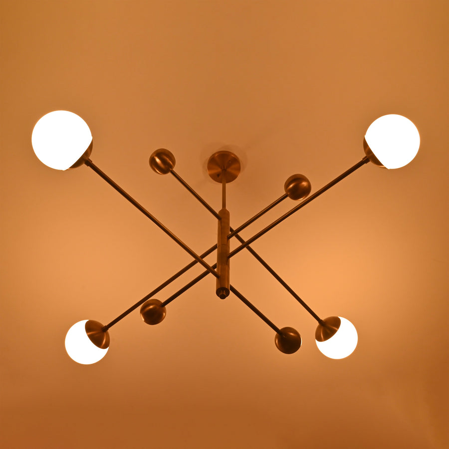 Front view of handcrafted solid brass 4-light chandelier with opal globes in sleek linear arrangement.