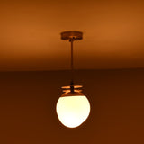 4 light brass linear chandelier illuminated in a dark setting, creating a warm and inviting ambient glow.