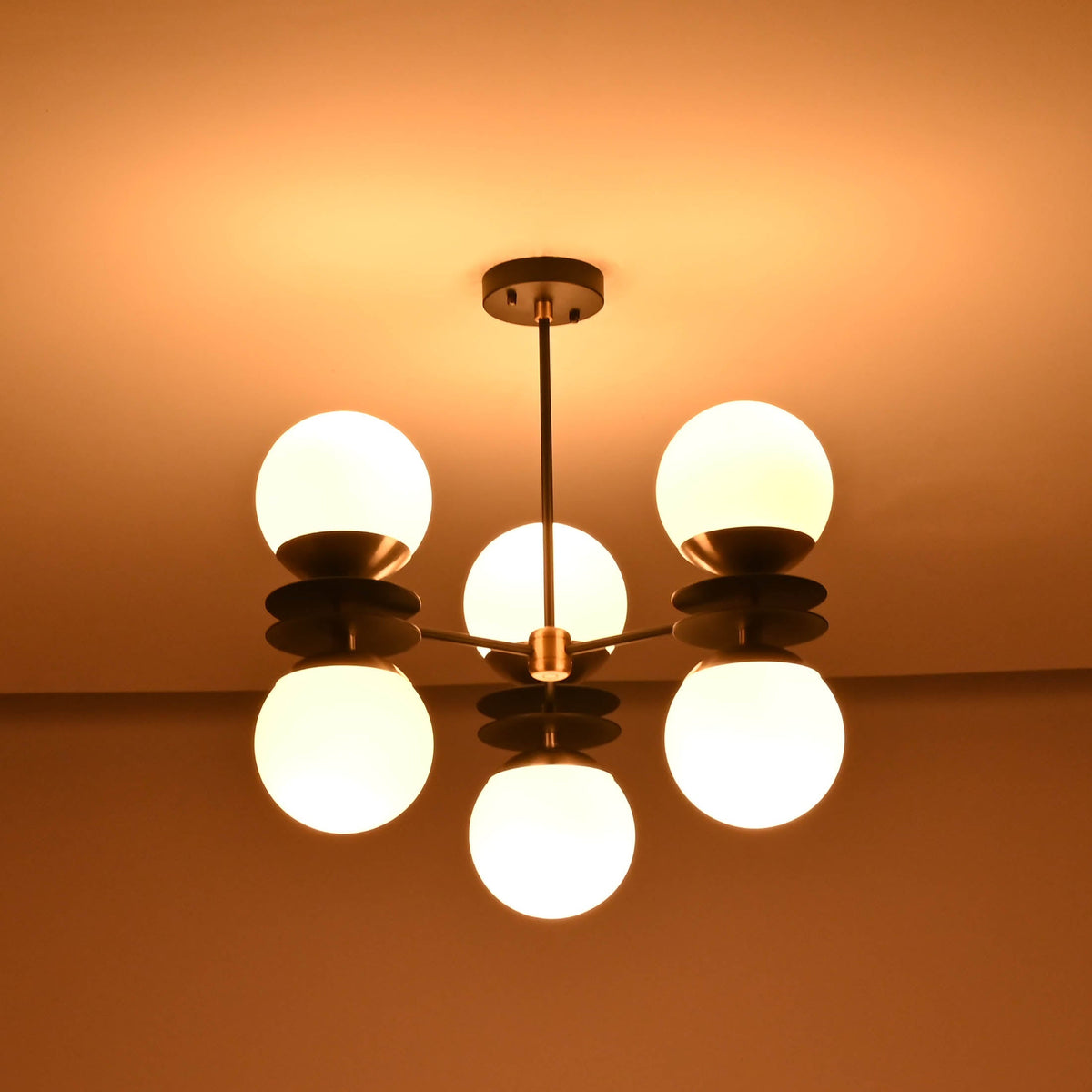 Six light brass chandelier with opal glass globes creating warm ambient glow in dark interior