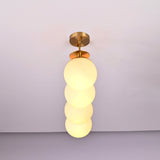 Vertical angle view of handcrafted brass chandelier featuring opal glass globes and brushed brass finish.