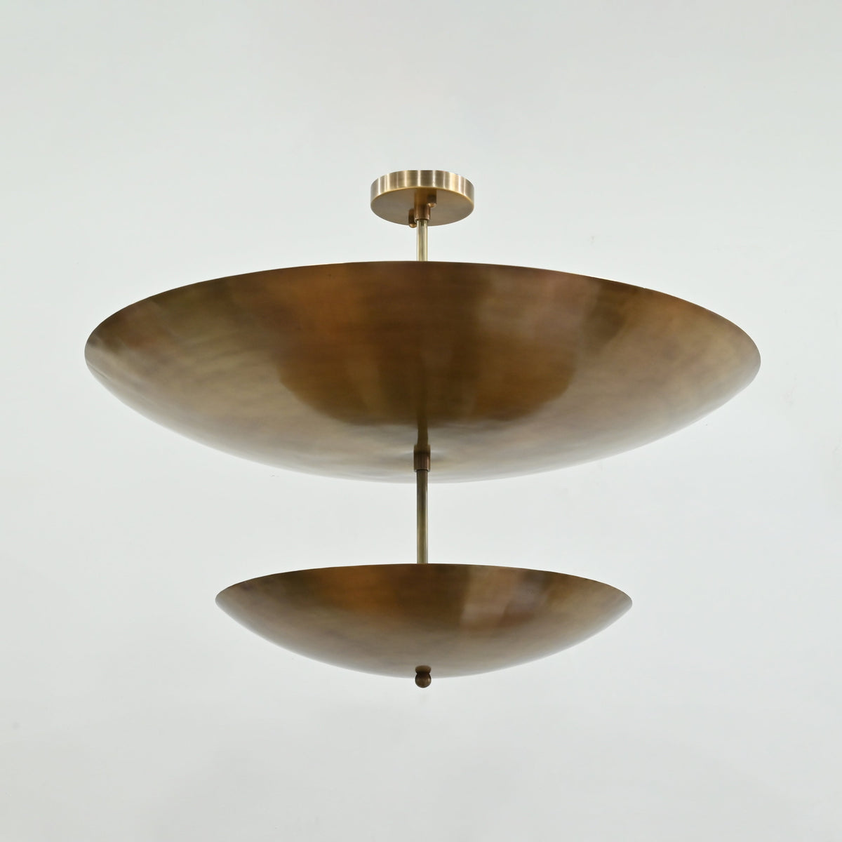 Brass Patina chandelier casting a warm golden ambient glow through its two-tier reflective disc design