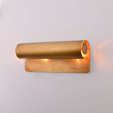 Brass Patina linear up down wall sconce shown above bedside table with warm ambient glow