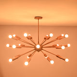 Brass sputnik chandelier glowing warmly in dark room creating dramatic ambient ceiling lighting.