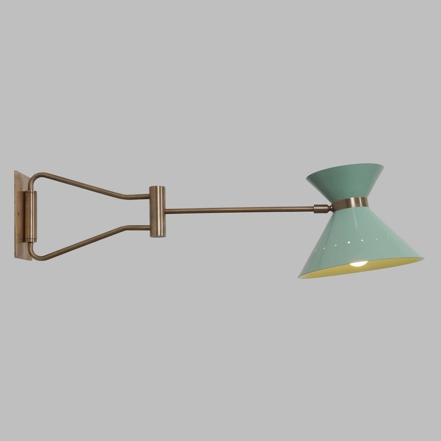 Adjustable brass swing arm wall lamp with sculptural cone shade, shown illuminated, handcrafted in solid brass by Brass Leaf Studio.