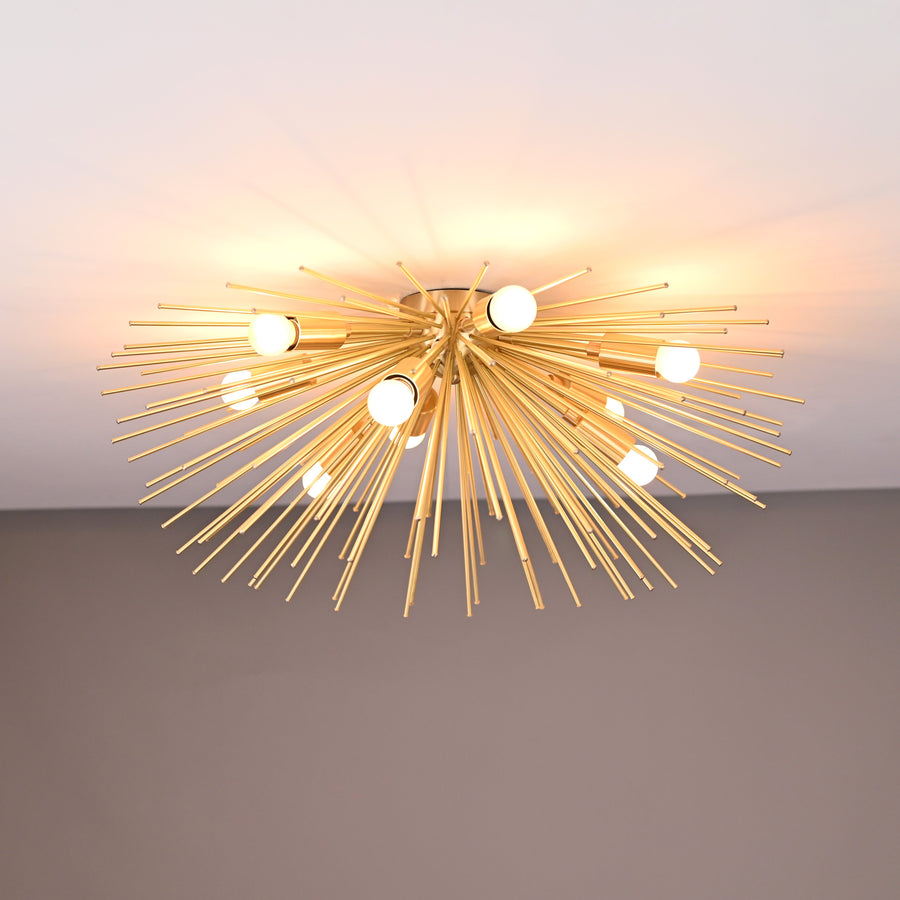 Brass urchin 9-light flushmount chandelier illuminated, showcasing radiant light spread and handcrafted brass rod design.