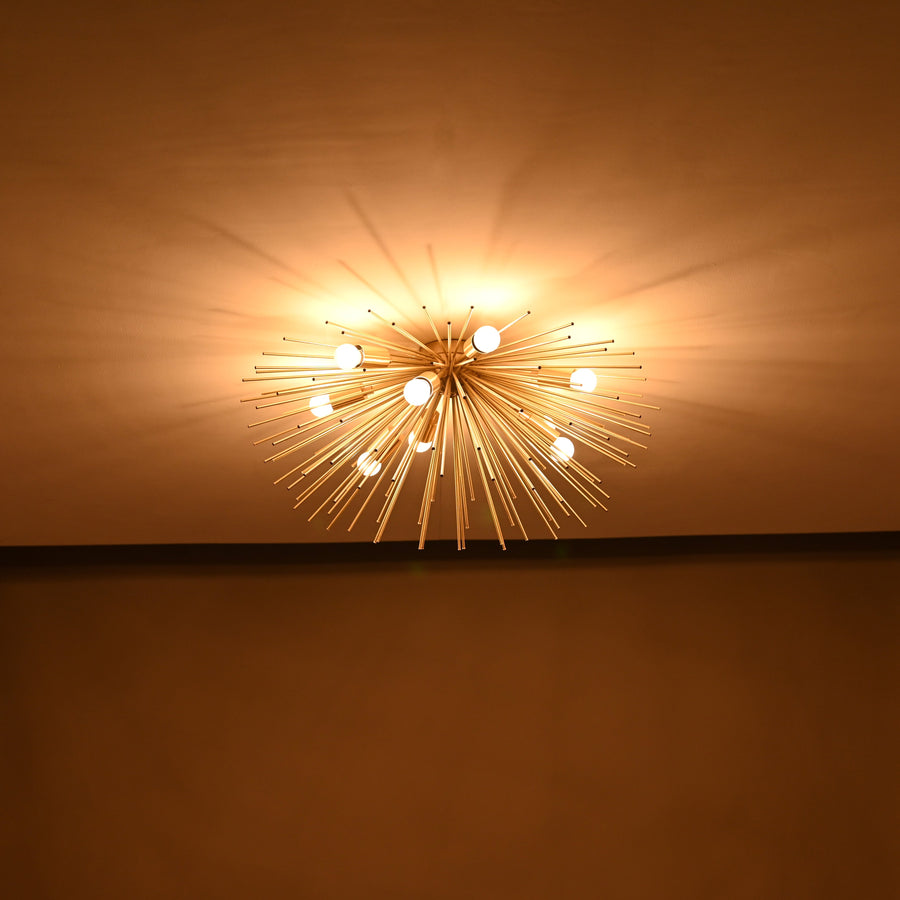 Brass urchin 9-light flushmount chandelier illuminated, showcasing radiant light spread and handcrafted brass rod design.