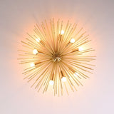Bottom angle view of brass urchin flushmount chandelier showing symmetrical spokes and glowing bulbs.