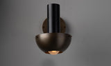 Front view of handcrafted brass wall light featuring a deep bowl shade and soft indirect glow for ambient interior lighting.