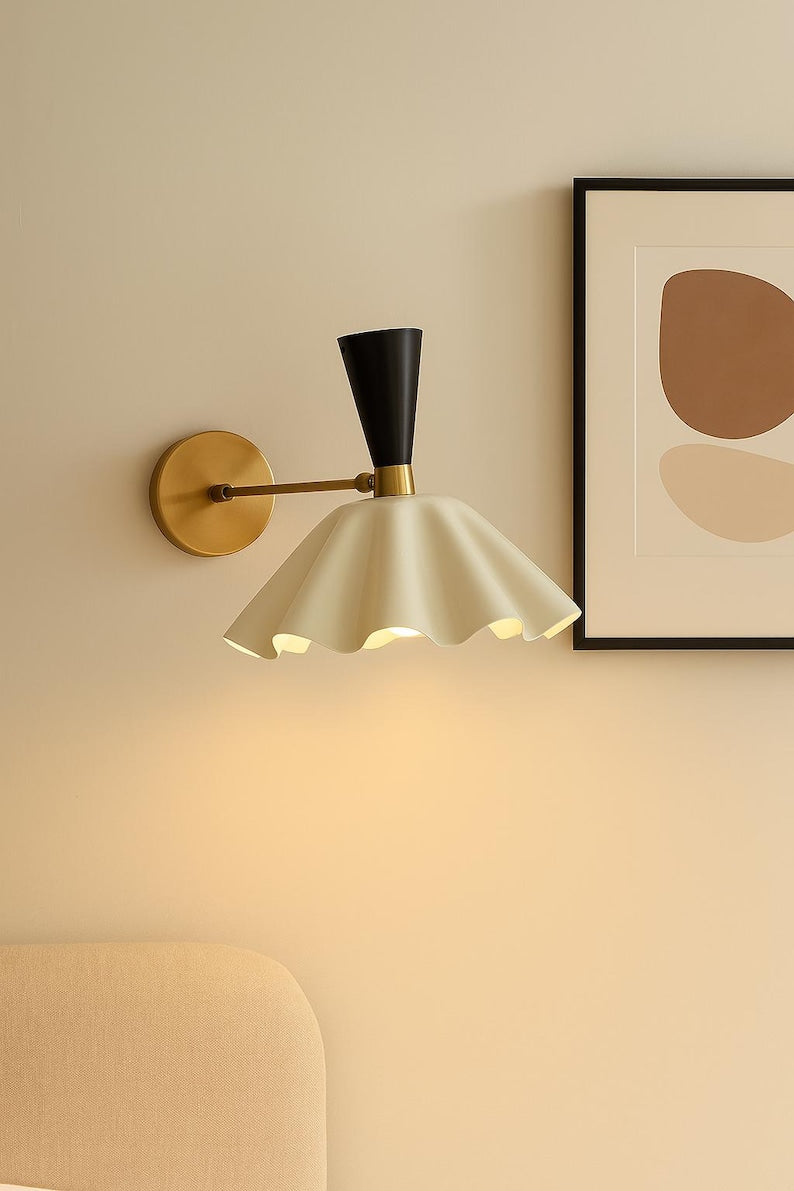 Solid brass wall sconce with sculptural fluted shade installed in modern living room interior providing warm ambient lighting
