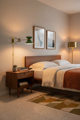 Brass wall sconce with green enamel shade, rectangular backplate, and extended adjustable arm