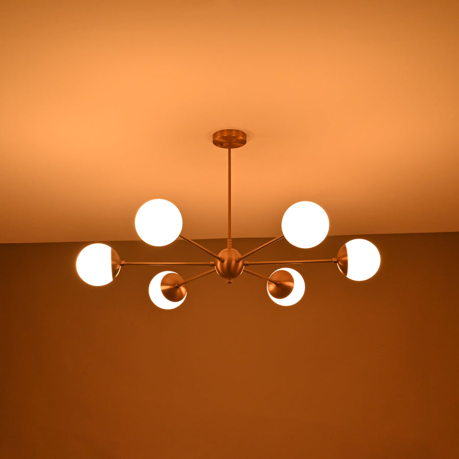 Handmade 6-globe brass chandelier featuring opal glass globes and brushed brass finish for modern interiors.