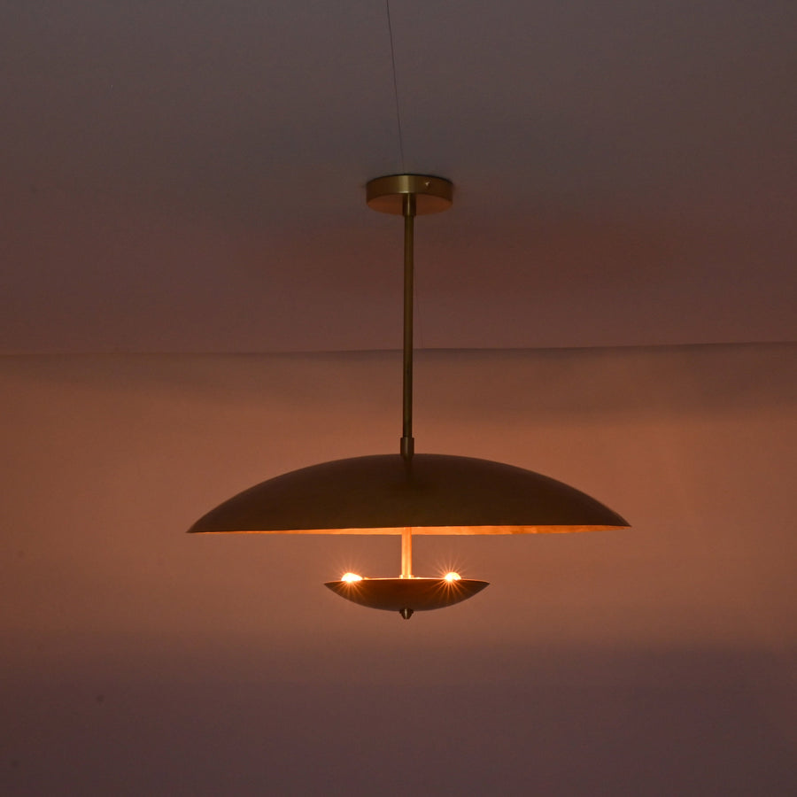 Front view of brushed brass disc pendant light with layered bowl shades and minimalist profile.