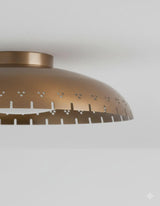 Close-up of brushed brass flush mount ceiling light showing perforated detailing and refined handcrafted finish