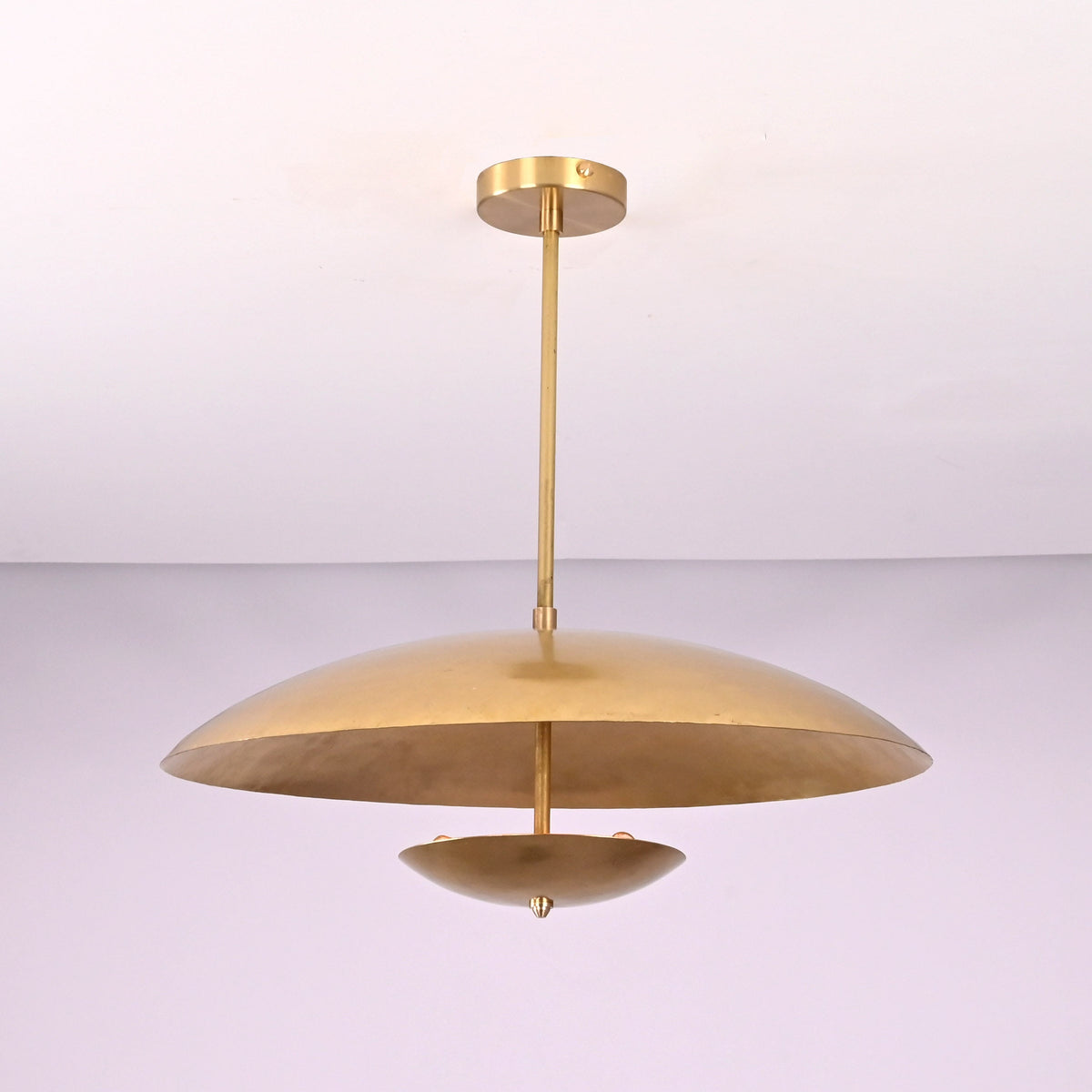 Side profile of modern brushed brass pendant light with wide bowl shade and clean silhouette.
