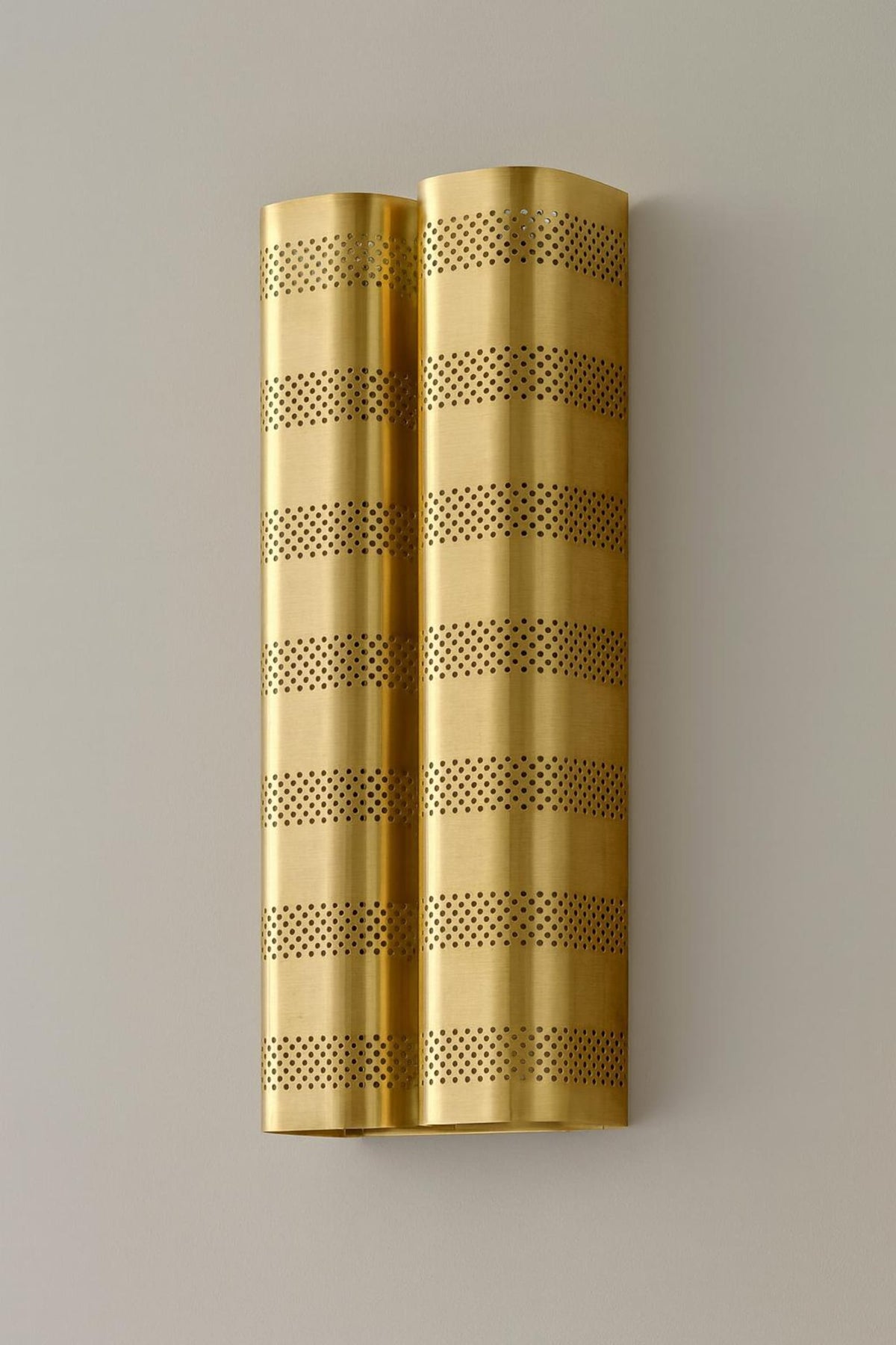 Side view of brushed brass perforated wall sconce showcasing cylindrical modern industrial design