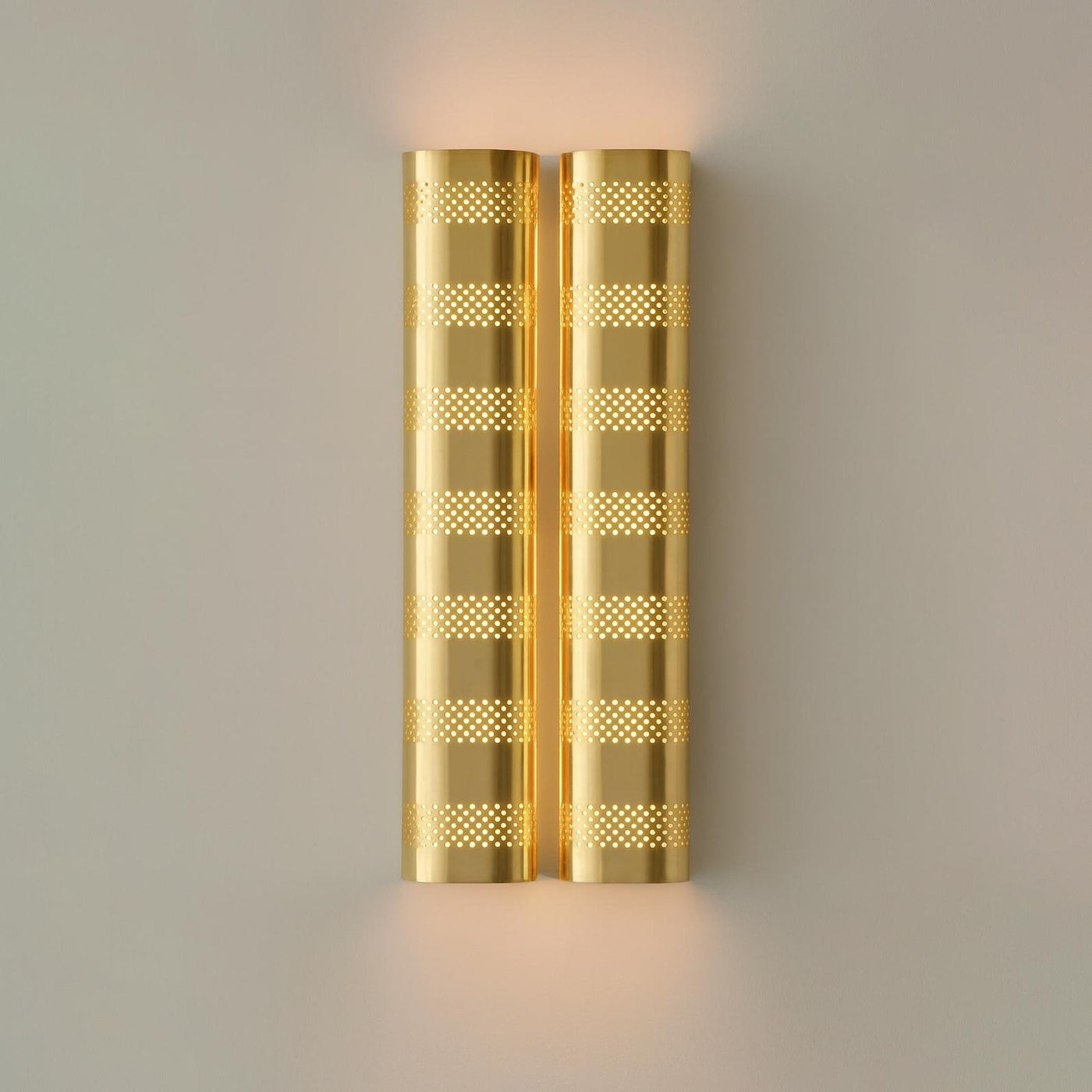 Brushed brass perforated wall sconce with warm ambient glow, modern industrial brass wall light by Brass Leaf Studio