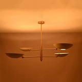 Brushed brass saucer chandelier shown from angled view with slim rods, central stem, and sculptural bowl shades