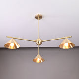 Three-arm brushed brass chandelier featuring sculpted cone shades and a minimalist industrial design.