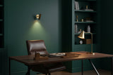 Casablanca brass wall sconce shown illuminated with soft warm light projected downward on the wall
