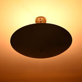 Blackened brass flushmount chandelier emitting soft warm light