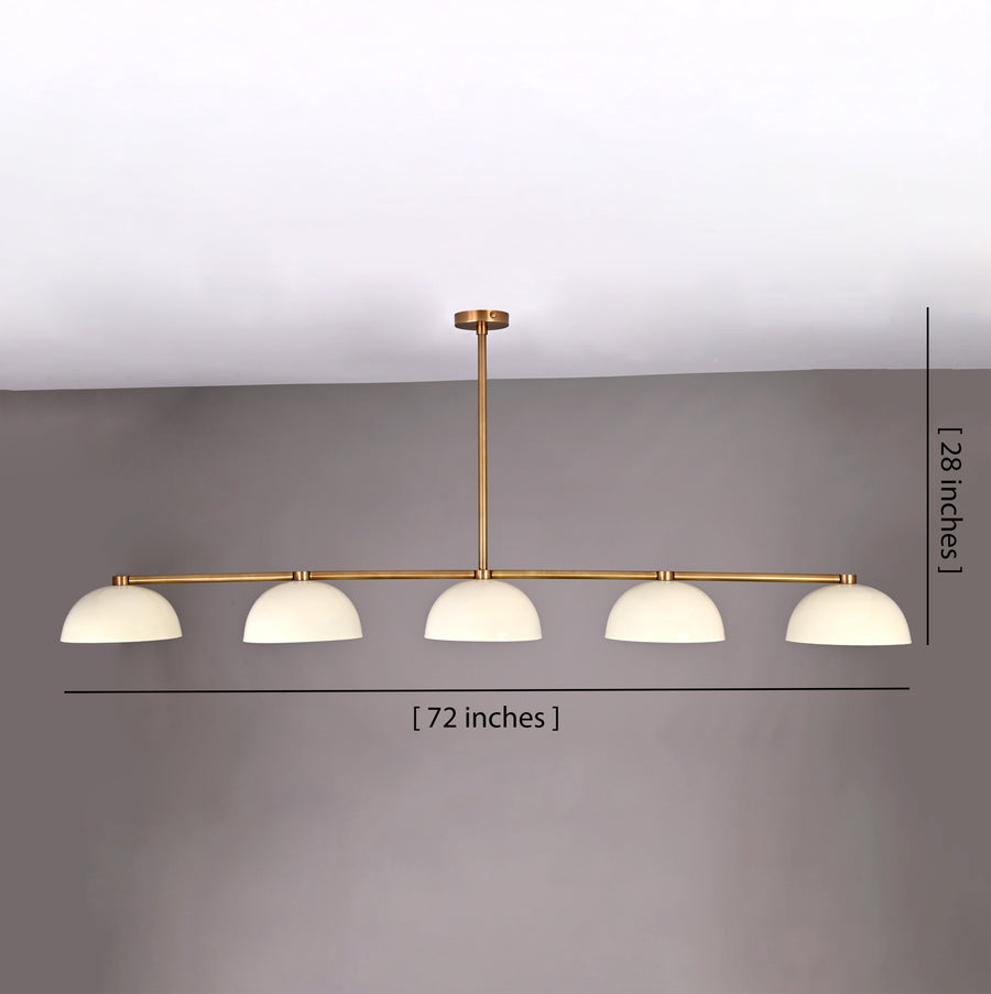 Front view of 72-inch wide, 28-inch tall linear brass chandelier with dome shades shown against a gray wall