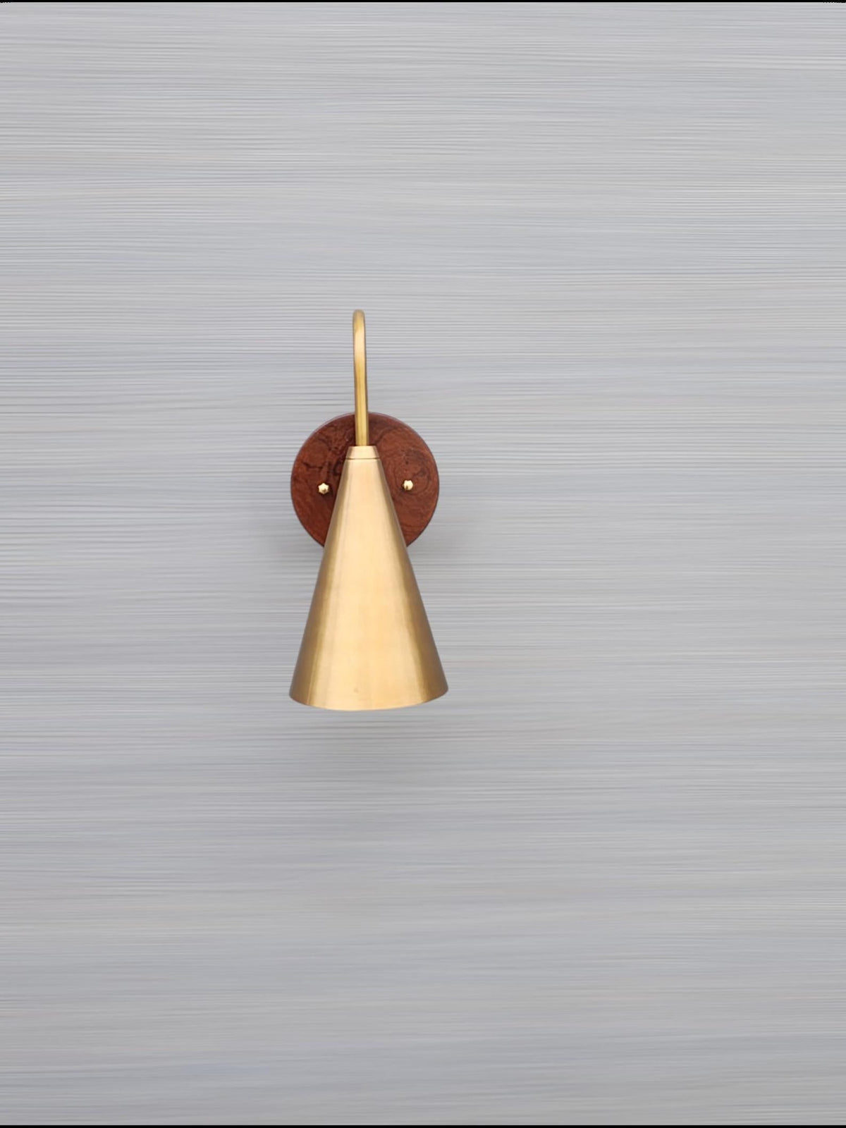 Mounted view of cone brass and wood wall light on neutral background showing refined craftsmanship and smooth brass patina.