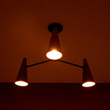 Copper cone chandelier casting warm ambient lighting for modern and industrial interiors