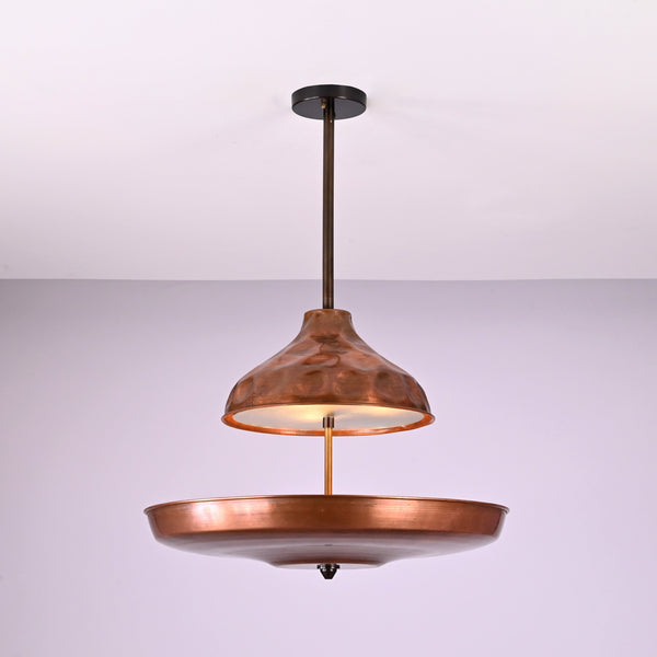 Modern copper disc chandelier with warm indirect lighting and sculptural bowl shade, handcrafted from solid brass
